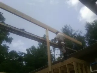 Carpenter setting a ridge beam over a new addition frame — Ice Dam Removal by Roofing Brothers in West Greenwich