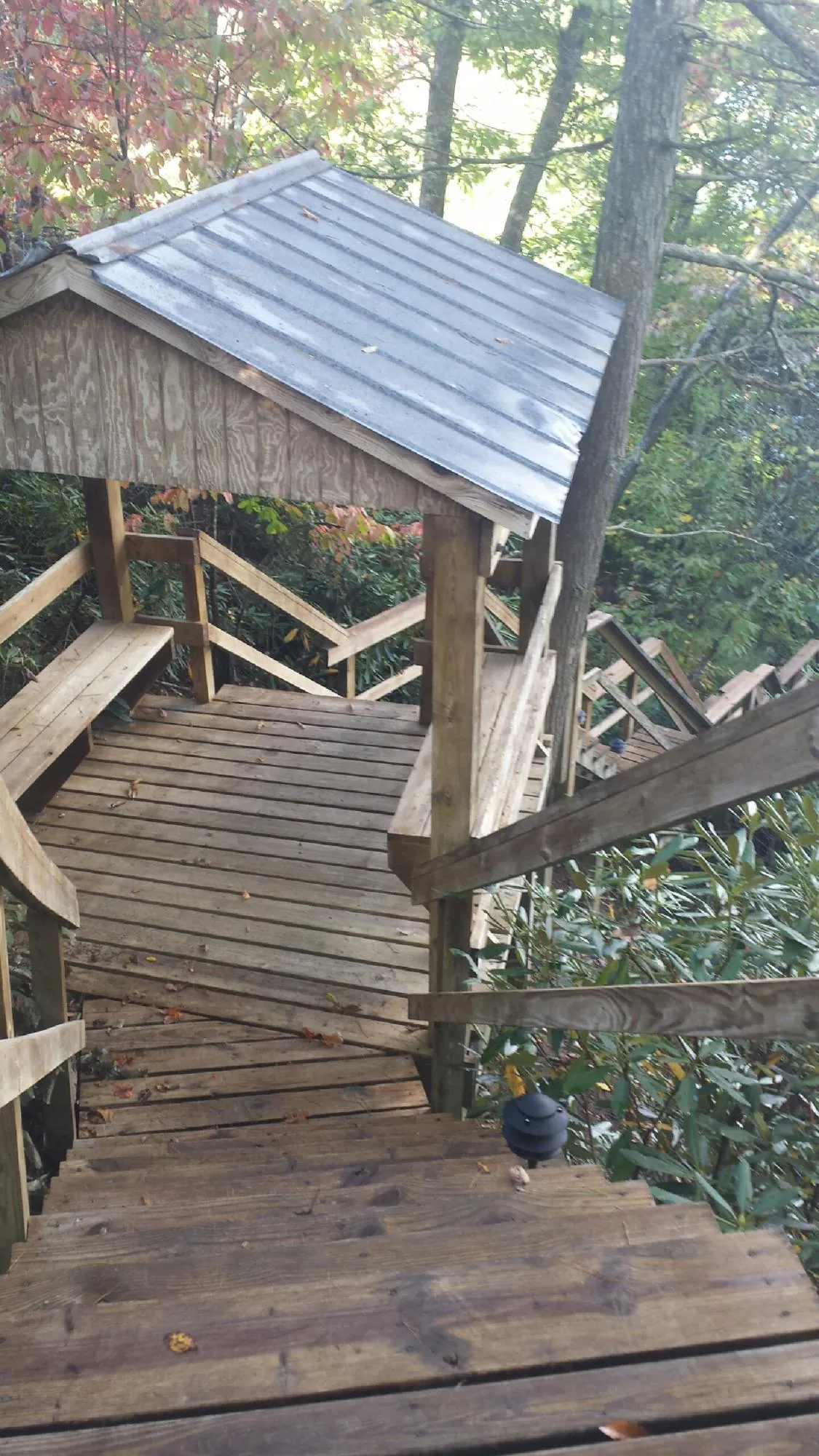 Metal roofed shelter over wooden steps on a wooded walkway — Skylight Repair & Installation work by our crew in West Greenwich